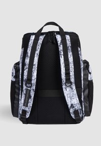 Sort rygsæk med en tekstureret mesh-ryg, hvid grafisk design, dobbelt sidelommer og justerbare sorte stropper med hardware-detaljer.