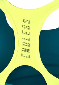 Bustier sportivo con un vivo giallo brillante e una base verde teal profondo. "ENDLESS" è stampato in orizzontale sulla parte posteriore.