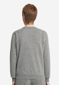 Szary sweter wykonany z miękkiej, teksturowanej tkaniny. Posiada okrągły dekolt, długie rękawy oraz prążkowane mankiety i dół. Widok z tyłu pokazuje minimalistyczny design.