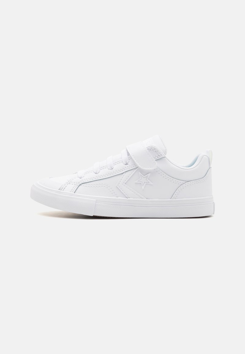 Baskets de sport blanches avec une finition en cuir lisse, bout rond, semelle plate en caoutchouc, lacets à l'avant et strap en Velcro. Emblème en forme d'étoile sur le côté.