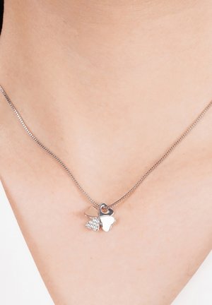 Zilveren ketting met twee hartbedels: de ene glad en glanzend, de andere versierd met kleine heldere steentjes, aan een delicate ketting.