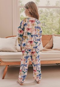 Ensemble de pyjama pour enfants avec un motif de nœuds et de rubans colorés, fabriqué en tissu léger avec des manches longues et un pantalon à taille élastique.