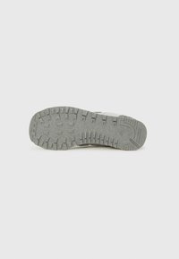 Suela de zapato deportivo gris con goma texturizada para agarre, que presenta un diseño de banda de rodadura con patrón y un detalle de marca en el lateral.