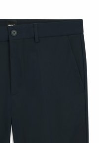 Marineblaue Hosen mit flachem Frontschnitt, einer seitlichen Tasche und Knopfverschluss. Hergestellt aus glattem Stoff mit feinen Nahtdetails.