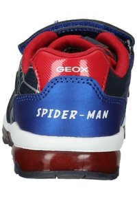 Scarpa da ginnastica blu con dettagli rossi, realizzata in materiale liscio e con il logo "SPIDER-MAN" sul tallone. Include un colletto imbottito e una striscia in velcro.