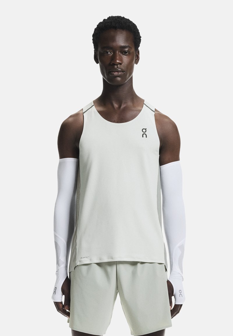 Débardeur de sport vert clair avec un col rond et des coutures minimales, associé à un short assorti ; comprend des manches blanches avec des accents en mesh.