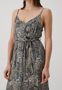 Robe gris à motif cachemire avec bretelles spaghetti ajustables, taille froncée et silhouette fluide. Tissu doux au toucher soyeux.