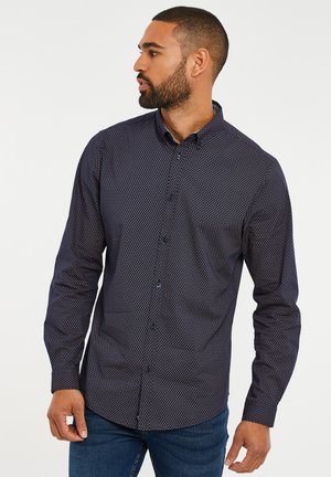 Marineblauwe overhemd met lange mouwen en een geometrisch patroon. Beschikt over een standaardkraag en blauwe knopen, gemaakt van een gladde stof.