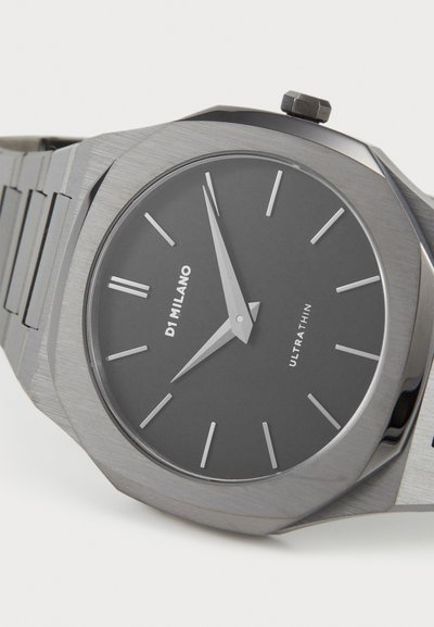 Stříbrné nerezové hodinky s kulatým matným černým ciferníkem, štíhlými ručičkami a minimalistickými indexy. Mají ultratenký design a osmiúhelníkový pouzdro.