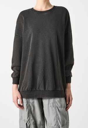 Sweatshirt gris foncé avec un col rond, des poignets froncés et un ourlet. Fabriqué en tissu doux, il présente une coupe décontractée et un minimum de détails.