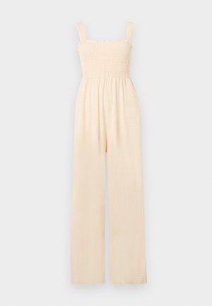 Cream-colored jumpsuit featuring a smocked bodice, spaghetti straps, wide legs, and soft fabric texture, suitable for casual wear.