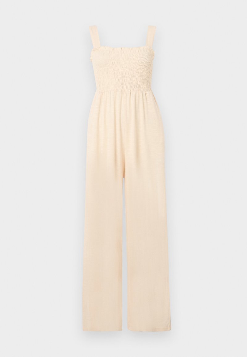 Jumpsuit w kolorze kremowym z marszczonym stanikiem, na ramiączkach spaghetti, szerokimi nogawkami oraz miękką teksturą materiału, idealny do codziennego noszenia.