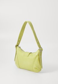 Sac à main jaune, texturé, avec une fermeture éclair, une courte bandoulière ajustable et des accents en métal. Présente un design épuré avec des formes angulaires.