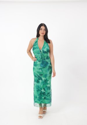 Maxi vestido floral verde con cuello halter, que presenta un escote en V profundo y detalle de cordón. Fabricado en tejido ligero y translúcido.