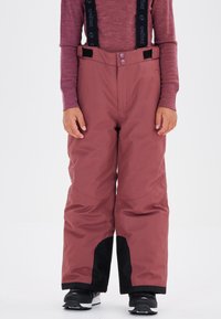 Pantalons de ski d'une couleur rose profond avec des accents noirs, fabriqués en matériau texturé et imperméable, dotés de poches cargo et de bretelles réglables.
