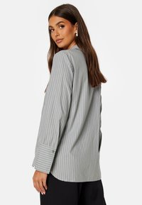 Grijze gestreepte shirt met lange mouwen, knoopmanchetten, zachte stof en een relaxte pasvorm. Kenmerkt zich door verticale witte strepen voor contrast.