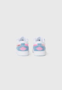 Une paire de baskets Air Jordan blanches, roses et bleu clair vues de l'arrière, avec un logo ailé rose sur les panneaux de talon en denim.