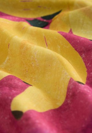 Gelber Stoff mit einem bunten Blumenmuster, das große gelbe Blütenblätter und pinke Akzente zeigt und eine weiche Textur sowie einen leichten Glanz aufweist.