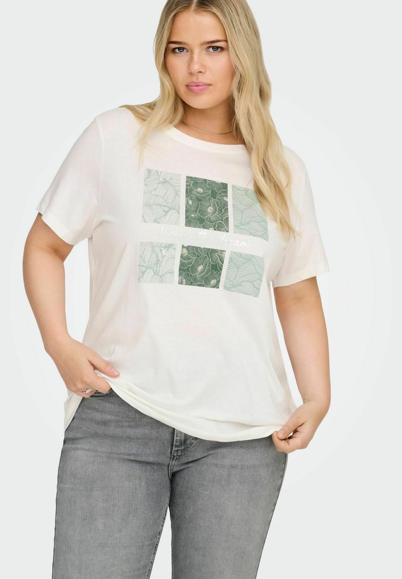 Roomkleurig T-shirt met een ontspannen pasvorm, voorzien van een groen botanisch printpaneel met vier vierkanten en de tekst "living the dream."