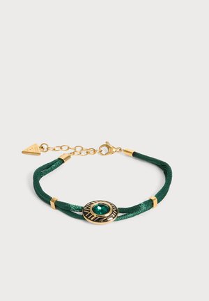 Bracelet en cordon tressé vert avec un sertissage ovale en or central présentant une pierre verte, et un fermoir chaîne réglable en or.