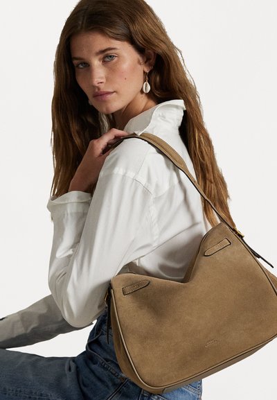Sac à épaule en daim tan avec une forme courbée et une surface texturée, doté d'une seule bandoulière et de subtils accents de couture.