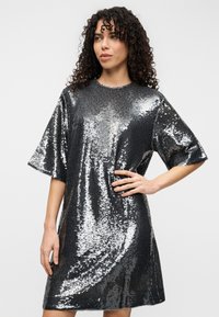 Φόρεμα με κοντά μανίκια από ασημί ύφασμα με παγιέτες, μέχρι το γόνατο, άνετη εφαρμογή, στρογγυλή λαιμόκοψη, με λεία υφή και αντανακλαστική επιφάνεια.