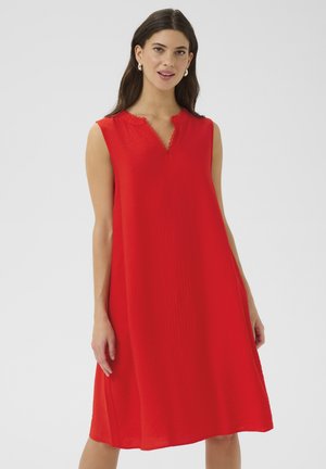 Red sleeveless dress with a V-neckline, textured fabric, and scalloped trim along the neckline. A-line silhouette that falls above the knee.