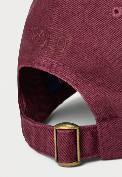 Bordo kokvilnas beisbola cepure ar izšūtu "POLO" aizmugurē, aprīkota ar metāla misiņa sprādzi regulēšanai un teksturētu audumu.