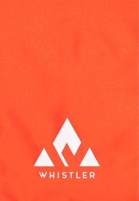 Kirkas oranssi reppu, jossa on sileä pinta, valkoisella vuoristosymbolilla ja sanalla "WHISTLER" rohkealla fontilla pohjassa.