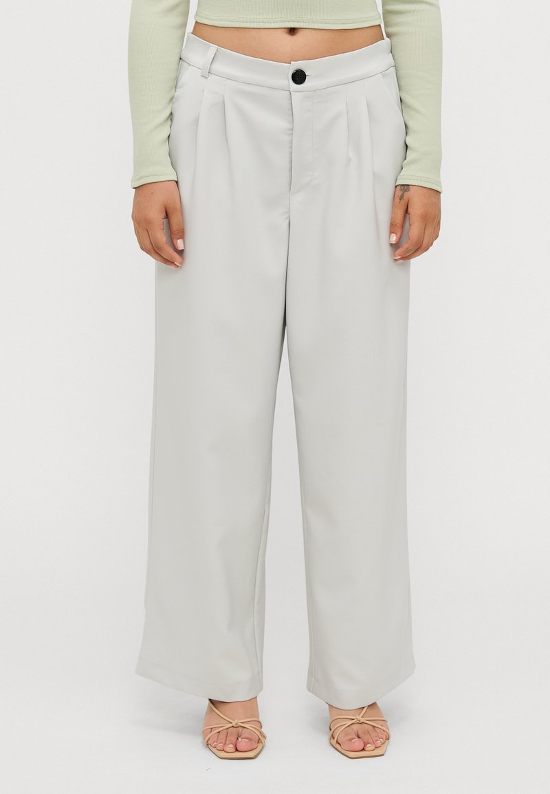 Wide-leg pants in light gray fabric, featuring a high waist, front pleats, and a single black button closure. Smooth texture and loose fit.