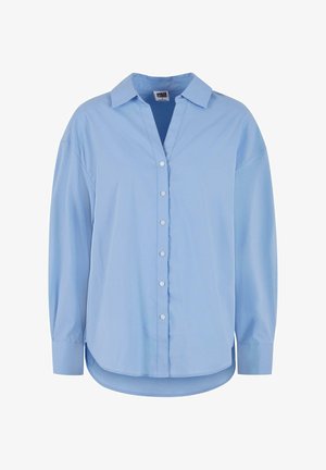 Šviesiai mėlyna marškinėlių palaidinė su apykakle, ilgomis rankovėmis ir apvaliu kraštu. Pagaminta iš lygaus audinio su šiek tiek laisvesniu siluetu ir be matomų raštų.