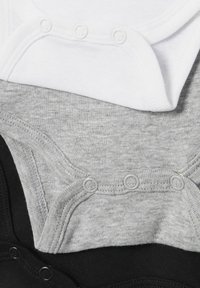 Trois bodies pour bébé en blanc, gris et noir. Fabriqués en coton doux, avec des boutons-pression et une texture lisse. Design classique.
