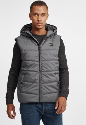 Gray sleeveless puffer vest with a hood, front zipper, and logo accent. Features quilted texture and snap closures on the sides.