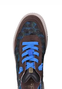 Sneaker con una toma in suede marrone, lacci blu e un lato in tessuto a motivo multicolore. Suola in gomma con un design testurizzato.