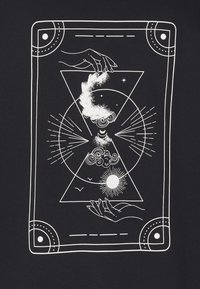 Deux mains encadrent une forme de sablier contenant le soleil, des nuages, un croissant de lune, des étoiles et de la poussière cosmique tourbillonnante dans un design géométrique.