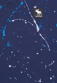 Granatowy sweatshirt z wzorem plam w niebieskim i białym kolorze, z czarną metką z logo łosia. Miękki, teksturowany materiał.