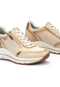 Baskets en cuir beige avec une fermeture éclair et des accents en rose gold, dotées de lacets blancs, d'une semelle rembourrée et d'une finition texturée.