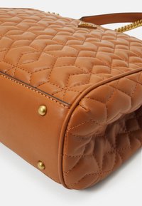 Borsa a tracolla in pelle marrone con motivo trapuntato, dettagli in metallo dorato e superficie liscia. Base robusta con borchie dorate per supporto.