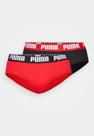 Rote und schwarze Baumwollunterwäsche mit breiten Gummibändern, die das "PUMA"-Logo in Weiß tragen. Jedes Paar hat ein nahtloses Design und eine glatte Textur.