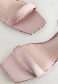 Sandale din satin roz cu toc plat, având un brâu superior lat și un design cu vârful pătrat, cu o textură netedă și strălucitoare pe suprafață.