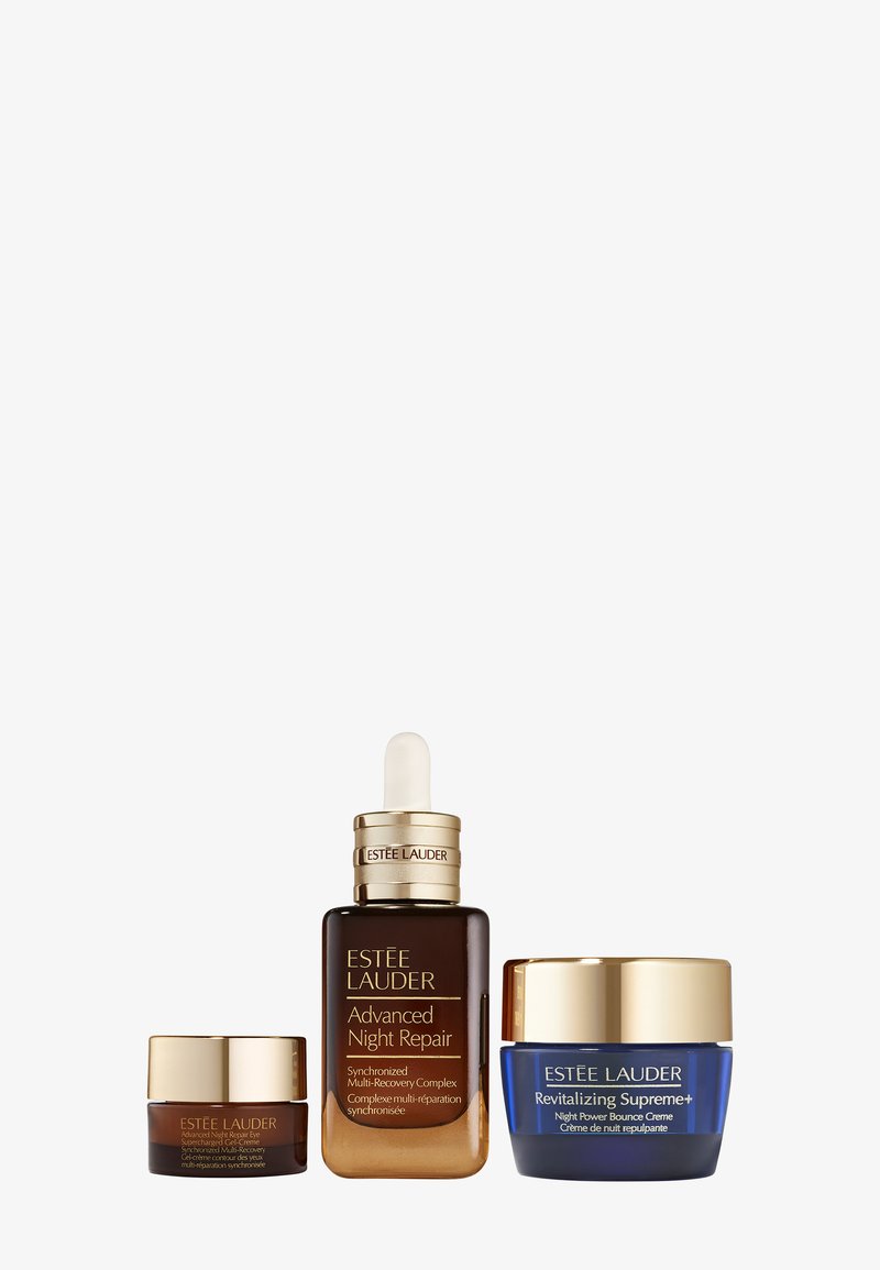 Estée Lauder hudvårdsset som innehåller en brun glasflaska med pipett, en liten mörk burk och en blå burk med guldaccenter.