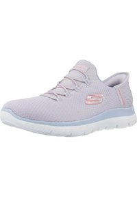 Zapatillas de malla color lila con punta redondeada, cordones elásticos y suela blanca. Presenta detalles texturizados y un logo en el costado.