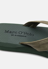 Green flip-flop with textured sole and olive fabric strap featuring embossed brand name "Marc O'Polo." Note the soft, durable materials.
