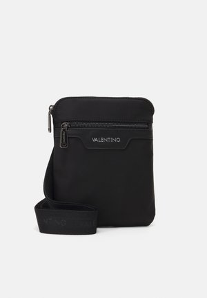 Borsa a tracolla nera in nylon con chiusura con zip, caratterizzata da una texture liscia e una tracolla con logo. Design compatto adatto per gli oggetti essenziali.