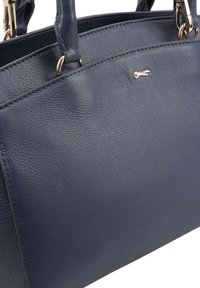 Marineleren handtas met een gepolijste textuur, dubbele handvaten bovenaan, gouden hardware en een klein logo-accent aan de voorkant.