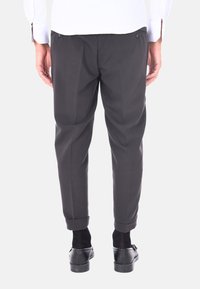 Pantaloni grigi scuri su misura con una vestibilità slim, frontale plissettato e orli arrotolati. Presentano tasche posteriori e una texture di tessuto liscia.