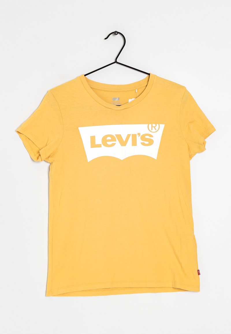 T-shirt jaune à manches courtes Levi's avec un logo blanc imprimé sur la poitrine, suspendu à un cintre noir sur fond blanc.