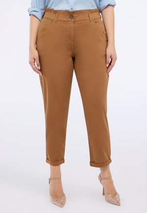 Braune Baumwoll-Chino-Hosen mit entspannter Passform, umgeschlagenen Säumen, vorderen Taschen und einem Knopfverschluss, kombiniert mit klaren Riemchen-Heels.