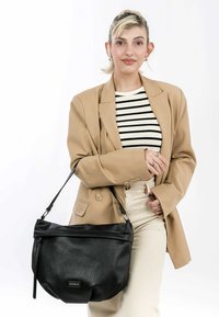 Black leather handbag with a textured surface, slouchy shape, and foldover top. Single shoulder strap and zip detail on the side.