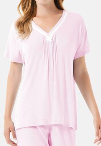 Top de pijama rosa de manga corta con escote en V, pliegues y encaje blanco, que presenta un ajuste relajado y una textura suave y lisa.